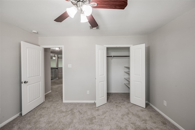 unfurnished bedroom featuring a closet, light colored carpet, and ceiling fan