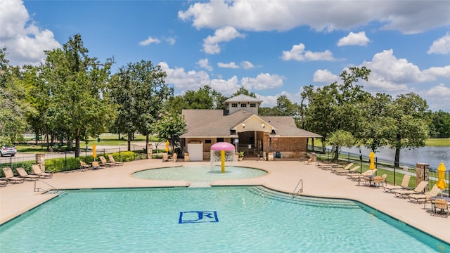 view of pool with a patio, a water view, and pool water feature