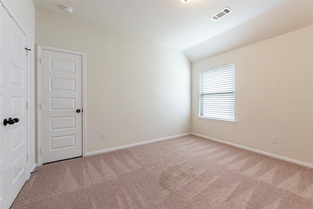 carpeted spare room with lofted ceiling