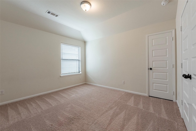 spare room with carpet floors and vaulted ceiling