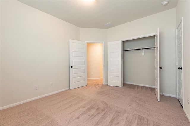 unfurnished bedroom with light carpet and a closet