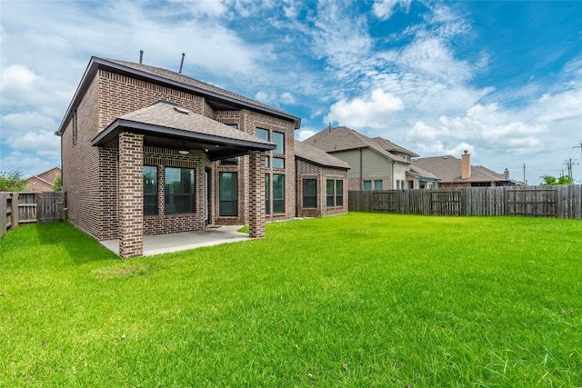 rear view of property featuring a yard and a patio