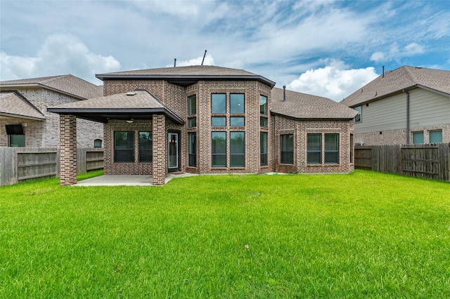 rear view of house featuring a patio area and a yard