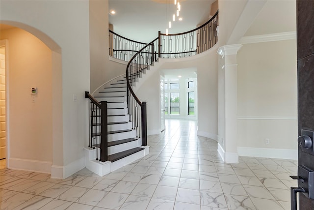 foyer featuring decorative columns and ornamental molding