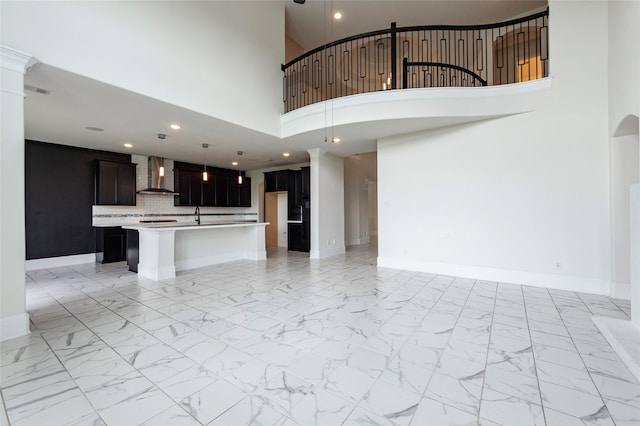 unfurnished living room with sink and a high ceiling