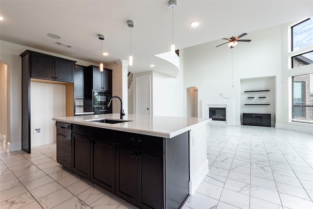 kitchen featuring a kitchen island with sink, sink, ceiling fan, black dishwasher, and built in microwave