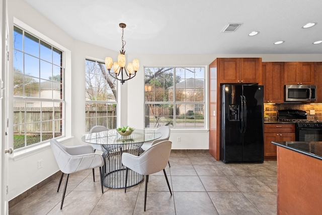 dining area with light tile patterned floors and a notable chandelier