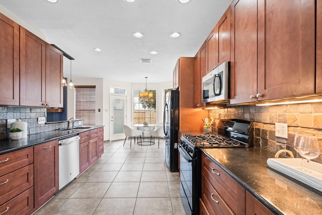 kitchen featuring pendant lighting, dark stone counters, black appliances, light tile patterned floors, and tasteful backsplash