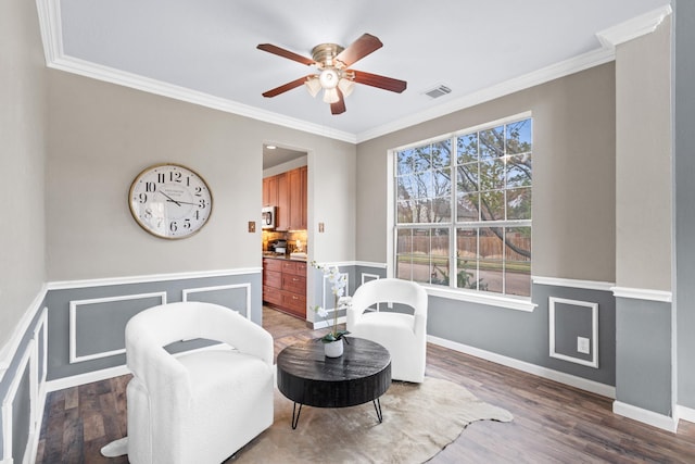 living area featuring ceiling fan, dark hardwood / wood-style flooring, and ornamental molding