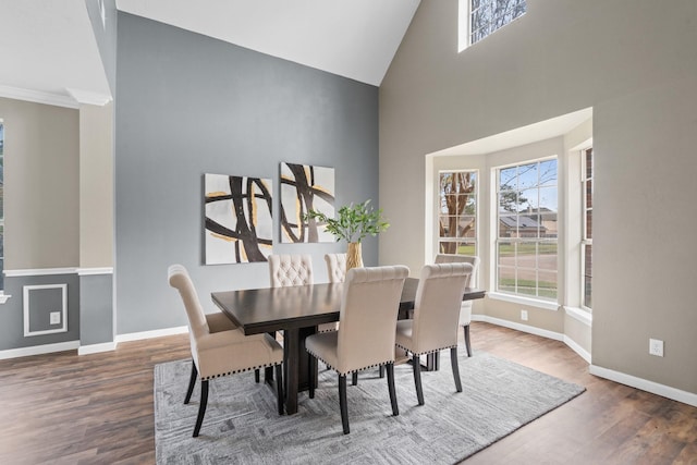 dining room with dark wood-type flooring and high vaulted ceiling