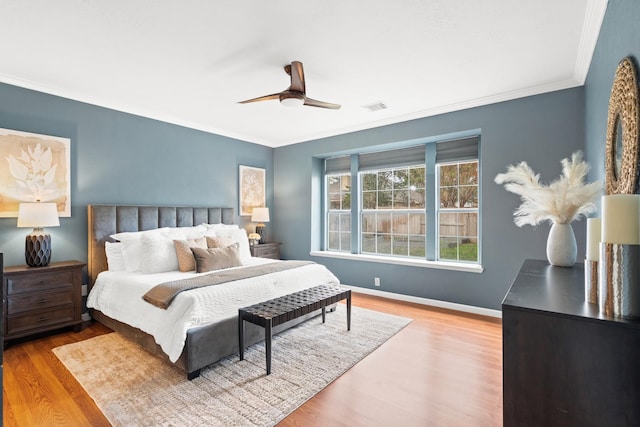 bedroom featuring light wood-type flooring, ceiling fan, and crown molding