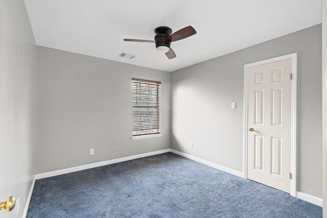 empty room with ceiling fan and dark carpet