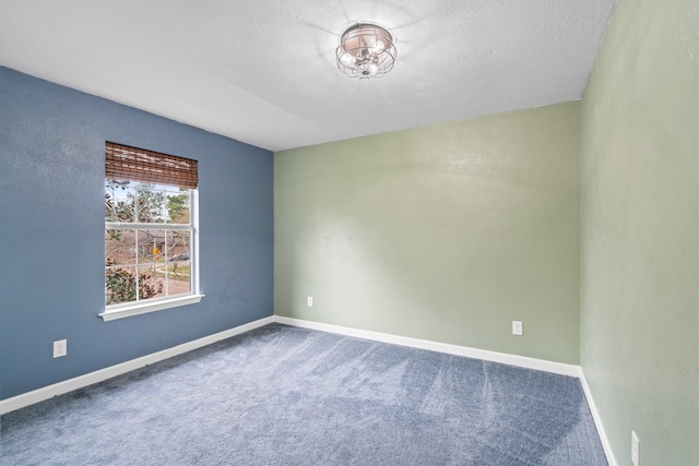 empty room with carpet flooring and a textured ceiling