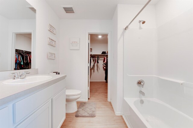 full bathroom with hardwood / wood-style floors, vanity, toilet, and washtub / shower combination