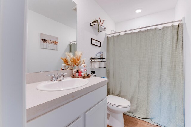 bathroom with vanity, hardwood / wood-style flooring, and toilet