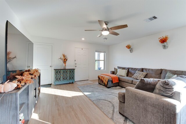 living room with light wood-type flooring and ceiling fan