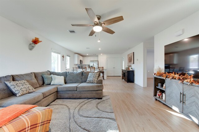 living room featuring ceiling fan and light wood-type flooring