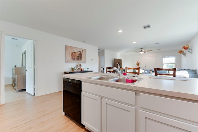 kitchen featuring white cabinetry, sink, ceiling fan, black dishwasher, and light hardwood / wood-style flooring