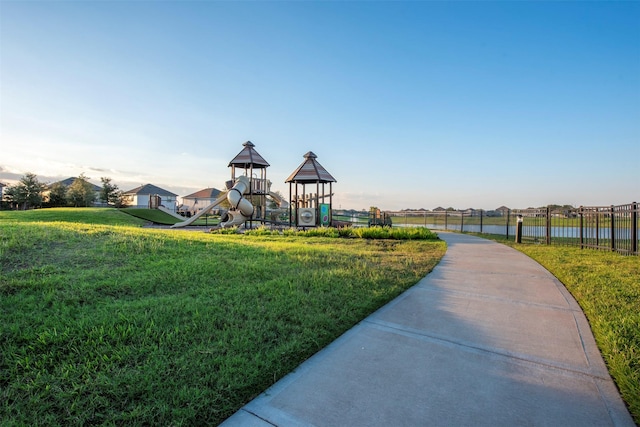 view of playground with a lawn and a water view