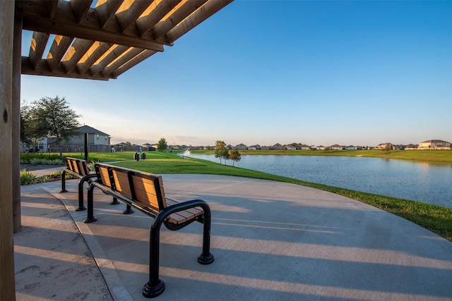 surrounding community with a lawn and a water view