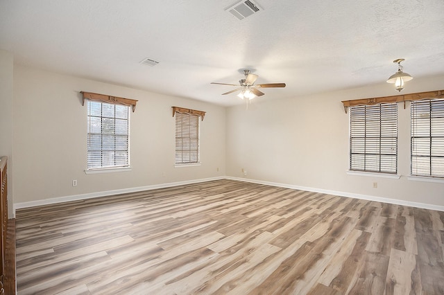 unfurnished room featuring a textured ceiling, hardwood / wood-style flooring, and ceiling fan