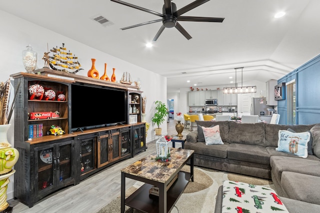 living room with light wood-type flooring and ceiling fan