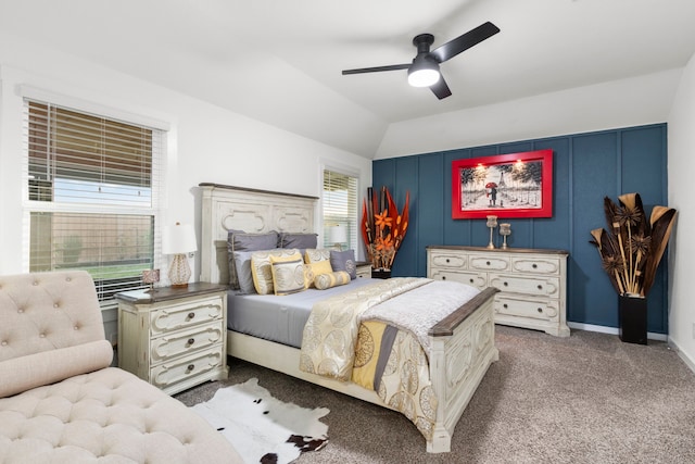 carpeted bedroom with multiple windows, ceiling fan, and vaulted ceiling