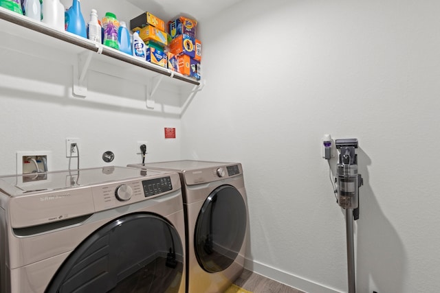 washroom with washing machine and clothes dryer and hardwood / wood-style flooring