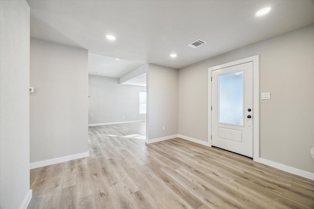 foyer entrance with light hardwood / wood-style floors and a healthy amount of sunlight