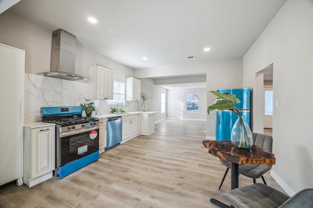 kitchen featuring dishwasher, backsplash, sink, wall chimney exhaust hood, and range with gas stovetop