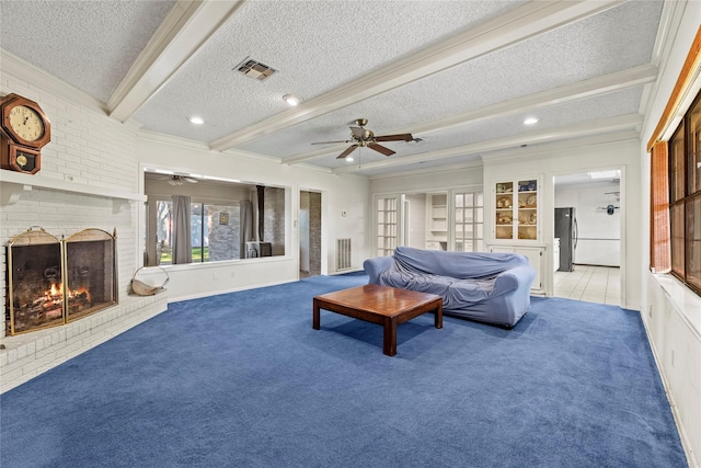 living room with carpet, ceiling fan, a fireplace, a textured ceiling, and beamed ceiling