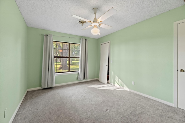 empty room featuring carpet, ceiling fan, and a textured ceiling