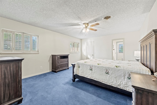 bedroom featuring multiple windows, ceiling fan, a textured ceiling, and dark colored carpet