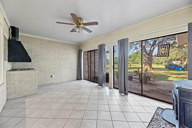 interior space featuring a wood stove and ceiling fan