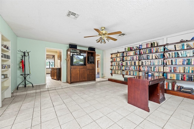 unfurnished office featuring ceiling fan and a textured ceiling