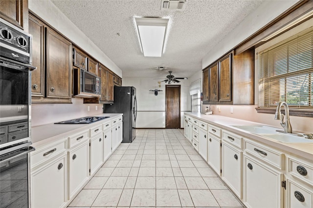 kitchen featuring black appliances, ceiling fan, white cabinets, and sink