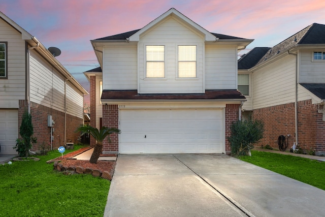 front facade featuring a garage and a lawn