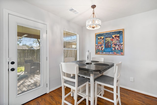 dining room featuring dark wood-type flooring and a chandelier