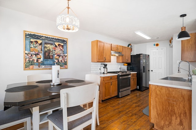 kitchen with decorative backsplash, sink, decorative light fixtures, and appliances with stainless steel finishes