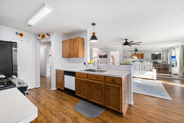 kitchen featuring decorative backsplash, sink, decorative light fixtures, dishwasher, and stainless steel refrigerator