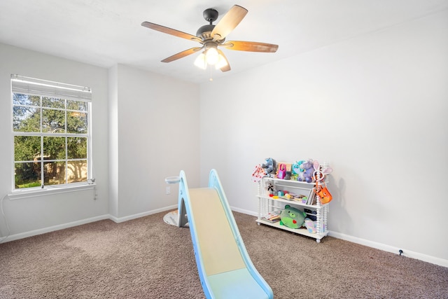 rec room with a ceiling fan, carpet, and baseboards