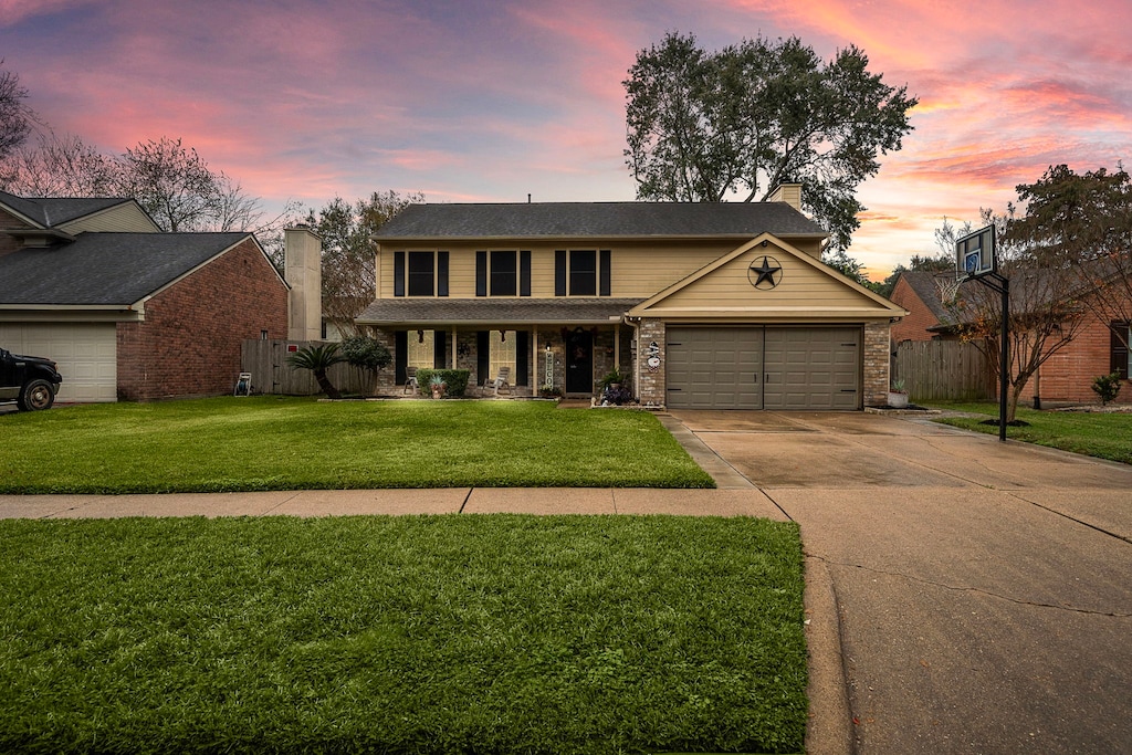 view of front of house with a garage and a lawn