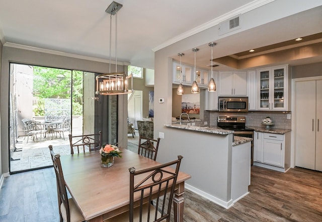 dining room with a chandelier, dark hardwood / wood-style flooring, and ornamental molding