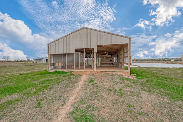 view of outbuilding with a yard and a water view