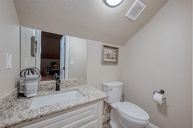 bathroom featuring vanity, vaulted ceiling, and toilet