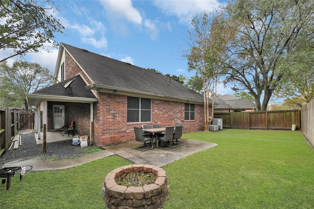 back of property featuring a lawn, cooling unit, a patio, and a fire pit