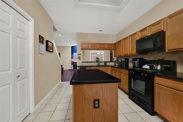 kitchen with backsplash, black appliances, sink, light tile patterned floors, and a kitchen island