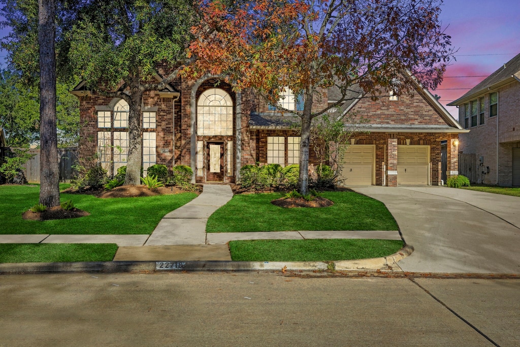 tudor house featuring a lawn and a garage