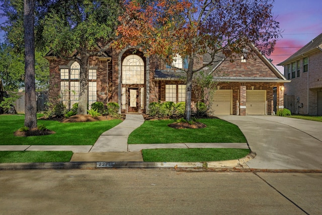 tudor house featuring a lawn and a garage