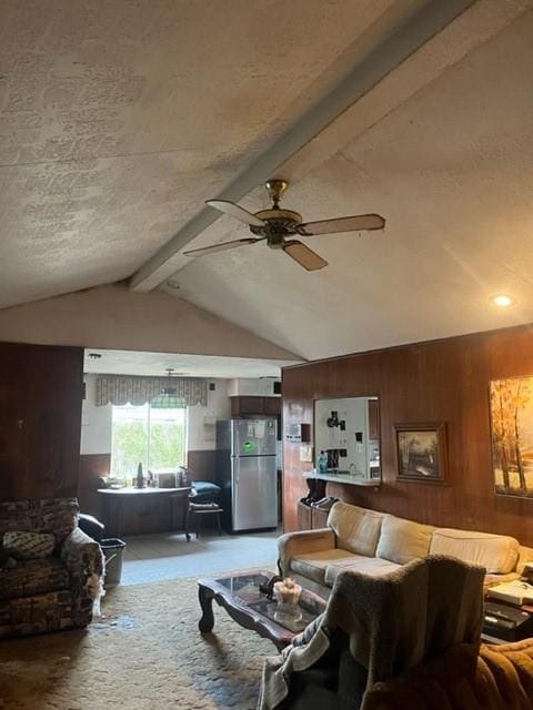 living room featuring carpet, vaulted ceiling with beams, ceiling fan, and wooden walls